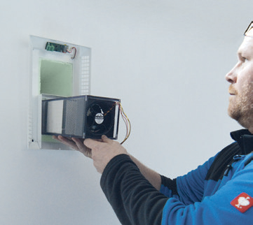 Installer fitting an AIRUNIT GEMINI single-room ventilation unit